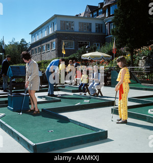 Negli anni sessanta la famiglia un gioco di golf in miniatura mamma papà 3 Bambini Estate VACANZA DIVERTIMENTO PUTT VERDE Foto Stock