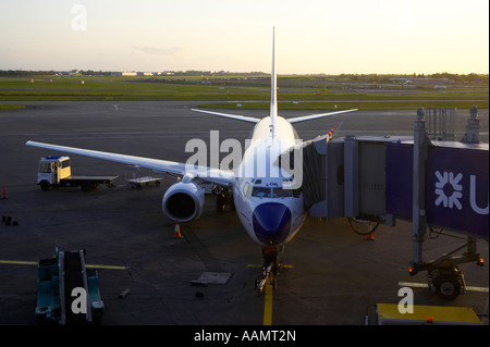 Malev Hungarian Airlines 737 700 LOR LOR ha parcheggiato a supporto di aeromobili con la passerella attaccato con pista in background a Dublino Foto Stock
