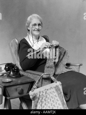 Trenta persone anziane donna sorridente indossando PINCE-NEZ OCCHIALI SEDUTA DELLA MAGLIERIA Foto Stock