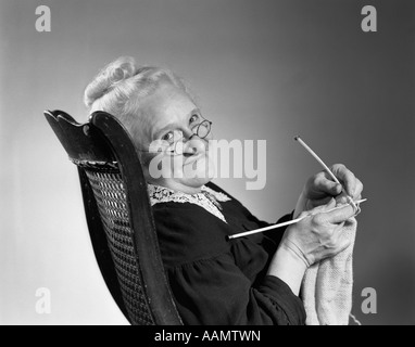 Anni Cinquanta anni sessanta anziani SENIOR Maglieria Donna sorridente girando guardando la telecamera che indossa gli occhiali della nonna Foto Stock