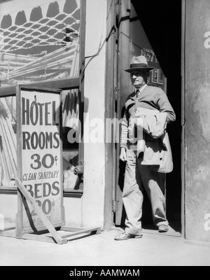 1930s uomo anziano A PIEDI FUORI DELLA PORTA ACCANTO ALLA LETTURA DEL SEGNO HOTEL CAMERE 30 centesimi pulite letti sanitari 20 centesimi Foto Stock