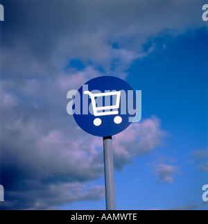 Carrello spesa illustrazione su un disco blu contro un cielo tempestoso in una Co op parcheggio del supermercato, REGNO UNITO Foto Stock