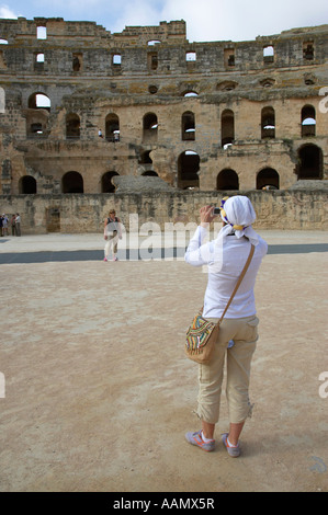 In prossimità di due turisti femminile prendendo foto sul pavimento arena del vecchio Colosseo romano di El Jem tunisia in verticale Foto Stock