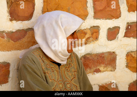 Troglodita berbero donna madre seduti all'ombra della sua dimora sotterranea della casa familiare a Matmata Tunisia Foto Stock