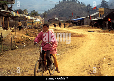 Le ragazze in sella giù collina, Bac Ha, Tonkinese Alpi, Vietnam del Nord Foto Stock