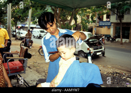 Ragazzo giovane avente taglio di capelli in Street, Città di Ho Chi Minh, Vietnam Foto Stock