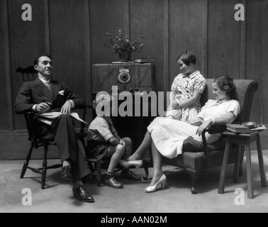 1930s 1940s famiglia seduto in salotto ascoltando la radio Foto Stock