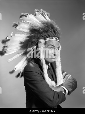 Anni sessanta ritratto uomo che indossa capo indiano FEATHERED copricapo Foto Stock