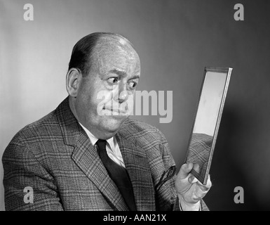 Anni sessanta RITRATTO DI BALDING UOMO CERCA NEL RETROVISORE Foto Stock