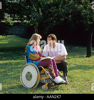 Donna disabile in sedia a rotelle e l uomo nel giardino Foto Stock