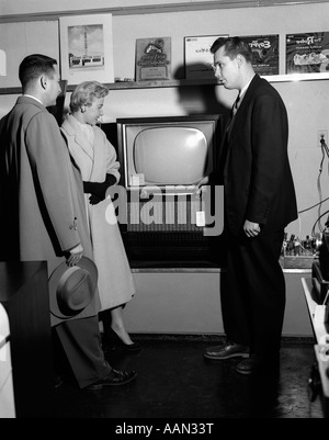 Anni Cinquanta matura CON IL VENDITORE IN APPARECCHIO ELETTRICO STORE SHOPPING PER LA TELEVISIONE Foto Stock