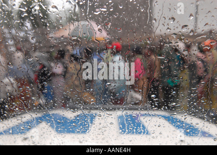 Sfollati interni in fila per gli aiuti visti attraverso il parabrezza del veicolo delle Nazioni Unite WFP in una giornata piovosa nella provincia del Nord Kivu, Repubblica Democratica del Congo, Africa Foto Stock