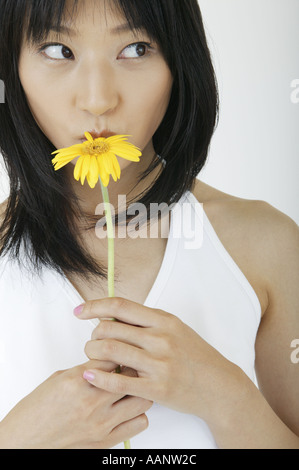 Una giovane donna baciare per un fiore Foto Stock