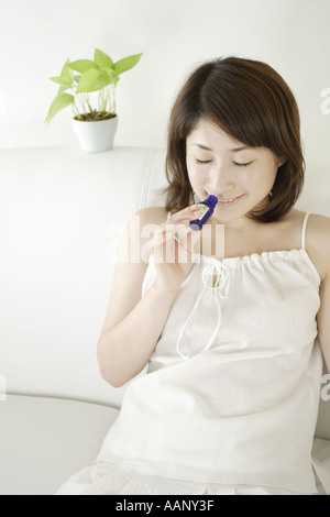 Una giovane donna odore di olio aromaterapia Foto Stock