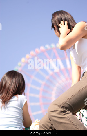 Due donne, ruota panoramica Ferris, vista posteriore Foto Stock