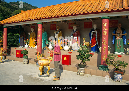 Uomo in piedi accanto al vaso di incenso, Diecimila Buddha Monastero, Sha Tin, Nuovi Territori di Hong Kong, Cina Foto Stock