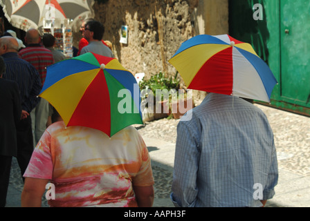Monreale Sicilia due turisti che indossano due ombrelloni in miniatura come protezione dal caldo sole Monreale Sicilia Italia Foto Stock