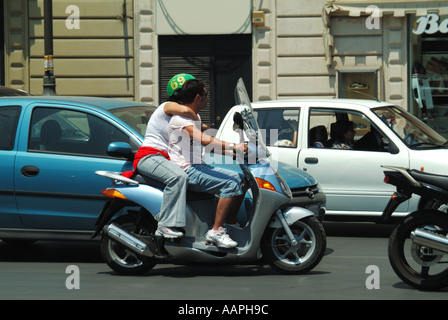 Palermo giovane su scooter tipo di ciclomotore motociclo in attesa ad un semaforo che indossa un casco uno non indossano il casco Foto Stock