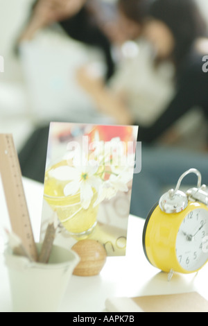 Orologio e cartolina con le giovani donne in background Foto Stock