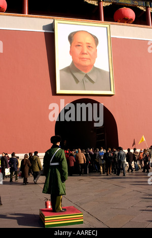 Il poliziotto cinese si erge nei pressi di massa Mao Tse Tung s immagine che si affaccia sulla città proibita ingresso gate Pechino CINA Foto Stock