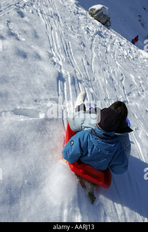 Due bambini slittino insieme sulla stessa slitta Foto Stock