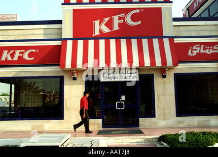 Un uomo camminano davanti a un ristorante fast food in Medio Oriente Foto Stock