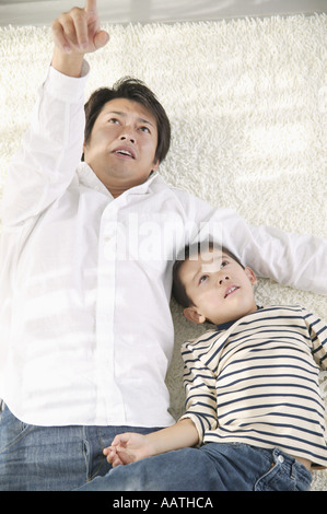 Padre e figlio sdraiato sul pavimento Foto Stock