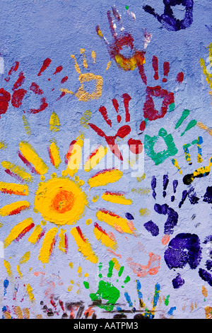 Pittura per bambini con stampe a mano e sun su una parete a Cowley Road in Oxford Foto Stock
