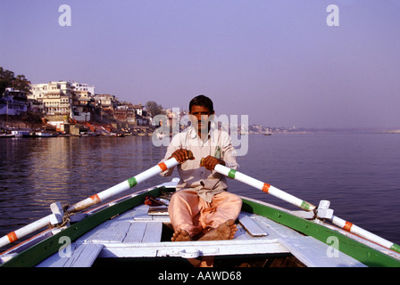 Boatman canottaggio sul fiume sacro Gange a Varanasi nello stato di Uttar Pradesh India Foto Stock