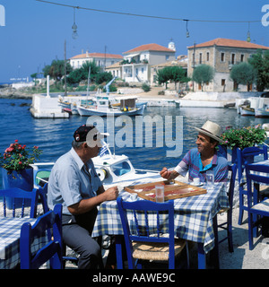 Gli uomini locali di giocare a backgammon a Aghios Nikolaos Harbour PELEPONESE Foto Stock