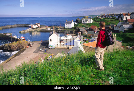 Passeggiate costiere walker guardando verso il basso sulla Scenic porto dei pescatori di St Abbs sulla costa Berwickshire Scottish Borders Scotland Regno Unito Foto Stock