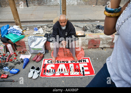 Un uomo orologi di vendita a Brick Lane street market nella zona est di Londra Foto Stock