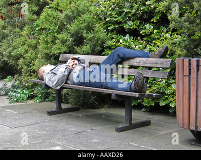 L'uomo addormentato sulla panchina nel sagrato giardino Soho London REGNO UNITO Foto Stock