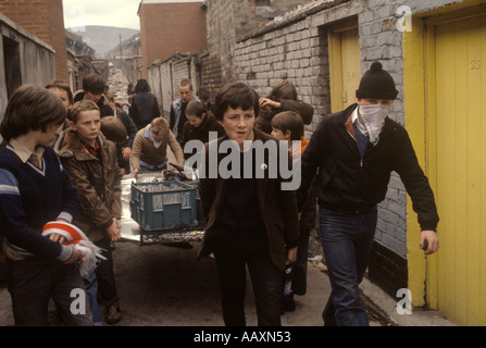 Irlanda i problemi. Belfast, anni 1980 I giovani cattolici adolescenti raccolgono materiale per realizzare bombe a benzina lanciate contro le truppe britanniche 1981 UK HOMER SYK Foto Stock