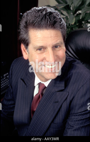 Ritratto di imprenditore sorridente e felice di fare affari in ufficio con tuta in verticale Foto Stock