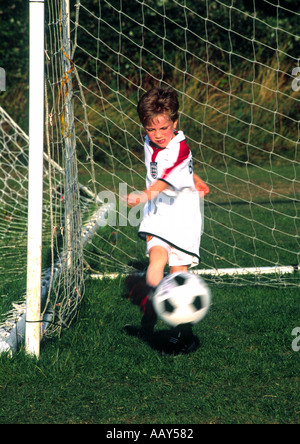 Ragazzo giovane calci calcio, il salvataggio di un obiettivo Foto Stock