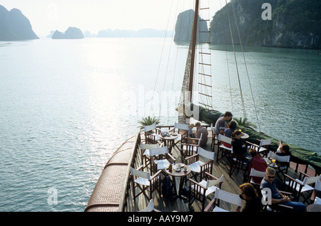 I turisti sul pianale superiore di una nave da crociera, la mattina presto, Halong Bay, Viet Nam Foto Stock