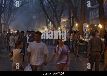 Xian, Shaanxi, Cina - il Quartiere Musulmano di Daqingzhen Si - la gente fuori in una trafficata strada di notte Foto Stock