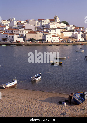 Algarve Ferragudo borgo oltre la spiaggia e ormeggiate barche da pesca in porto Foto Stock