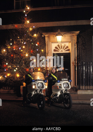 Numero dieci di Downing street porta anteriore residenza ufficiale del Primo Ministro britannico motociclisti di polizia & albero di Natale Westminster Londra Inghilterra REGNO UNITO Foto Stock