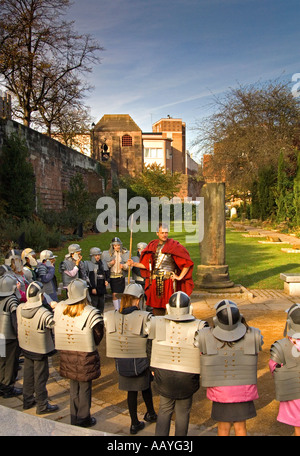 Legionario romano mostra un gruppo di bambini delle scuole intorno ai giardini romano a Chester, Cheshire, Inghilterra, Regno Unito Foto Stock