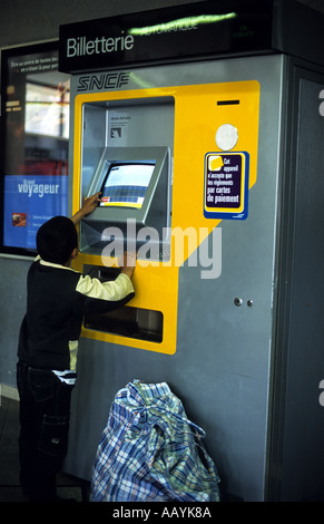 Ragazzo di acquistare un biglietto ferroviario da un distributore automatico, Parigi, Francia Foto Stock