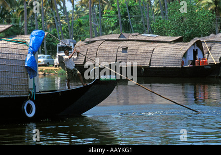 Un uomo su una barca sul backwaters del Kerala, India. Foto Stock