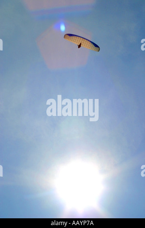 Parapendio aginst blu cielo con Sun al fondo di shot Foto Stock