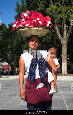 Madre, cesto di rose sul suo capo, e baby, Zocalo, la piazza principale del paese, Oaxaca, Stato di Oaxaca, Messico Foto Stock
