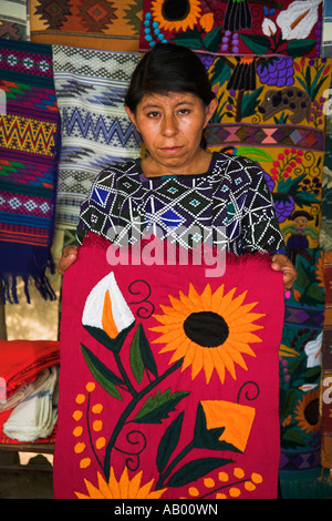 Signora azienda colorato tovaglia, San Lorenzo Zinacantan, vicino a San Cristobal de las Casas, Chiapas, Messico Foto Stock