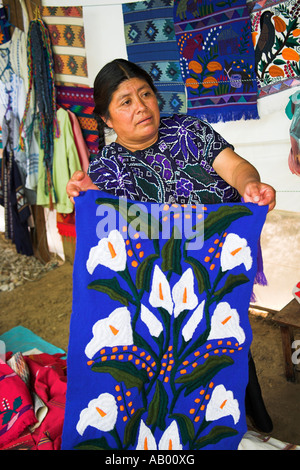 Signora azienda colorato tovaglia, San Lorenzo Zinacantan, vicino a San Cristobal de las Casas, Chiapas, Messico Foto Stock