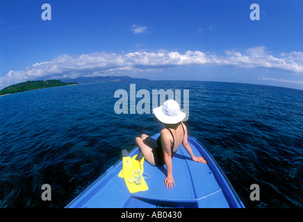 Donna in costume da bagno seduto sulla prua della barca fuori dell'Isola di Lombok in Indonesia Asia Sudorientale Modello rilasciato image Foto Stock
