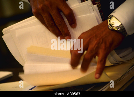 Mani di African American businessman ordinamento attraverso carte Foto Stock