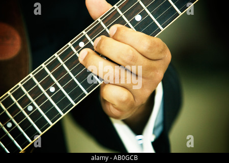 Chitarristi sinistro note da sfregamento sul collo di una chitarra Foto Stock